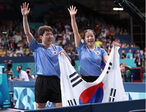 태극기를 들고 있는 신유빈 임종훈