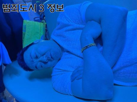 배우 마동석이 누워있는데 팔뚝이 두꺼워 머리가 바닥에 닿지 않는 모습