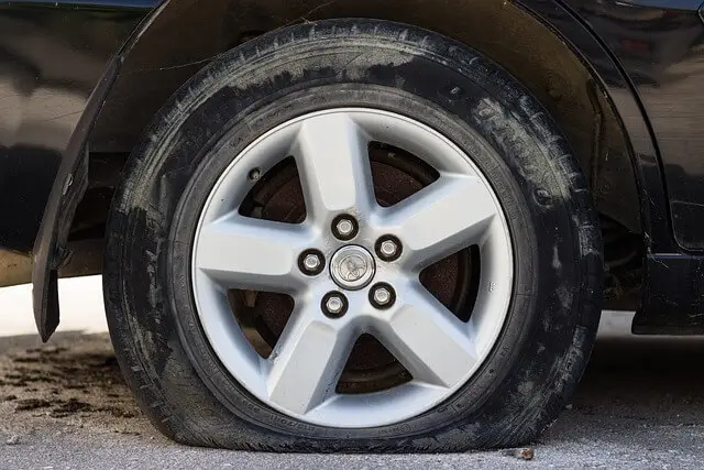 회색 도로위 완전히 바람빠진 타이어