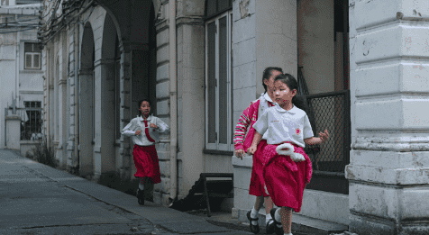Three children are running in the city