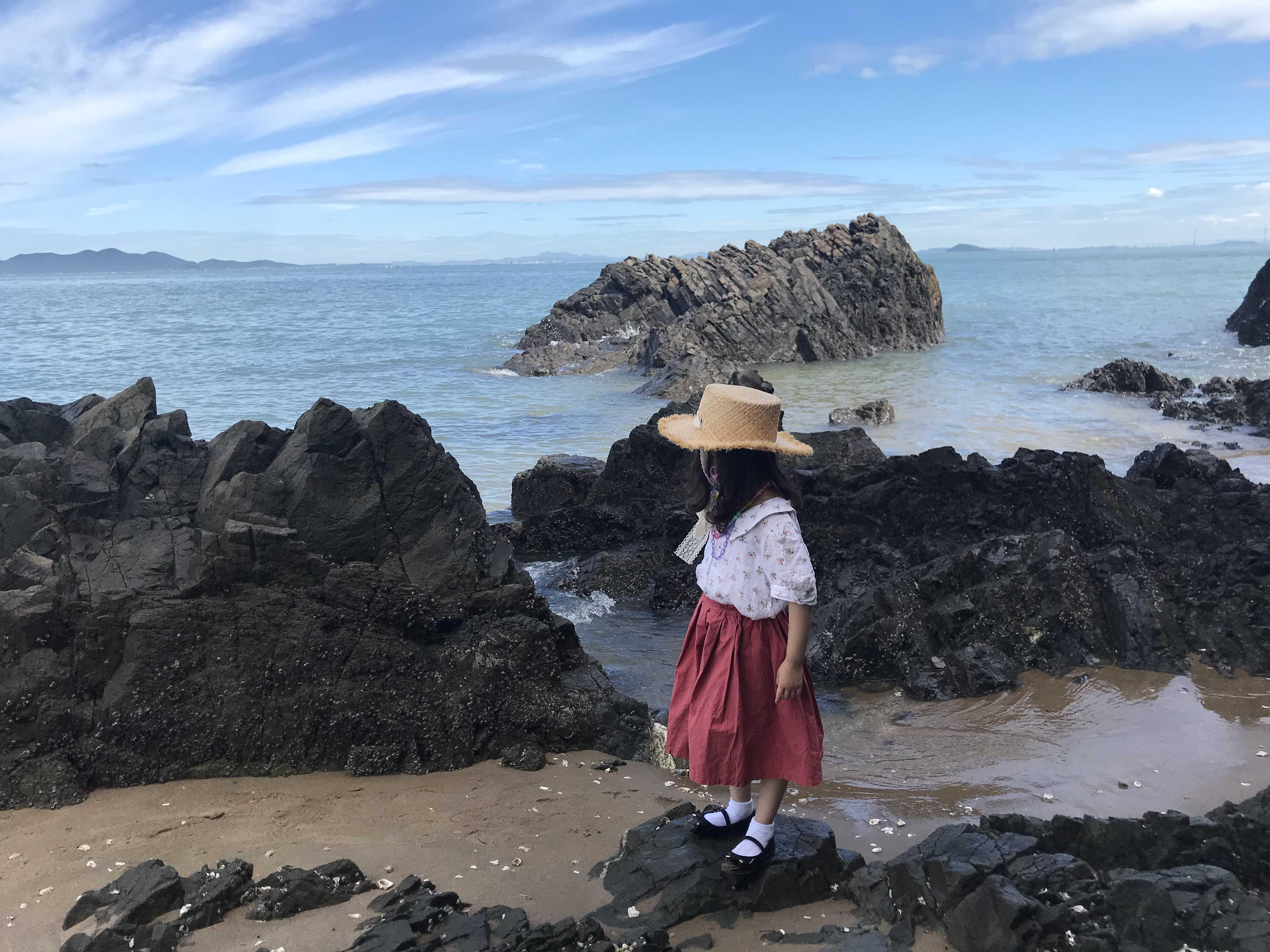 인천 영흥도 카페 하이바다 앞 해변 돌에 서있는 아이