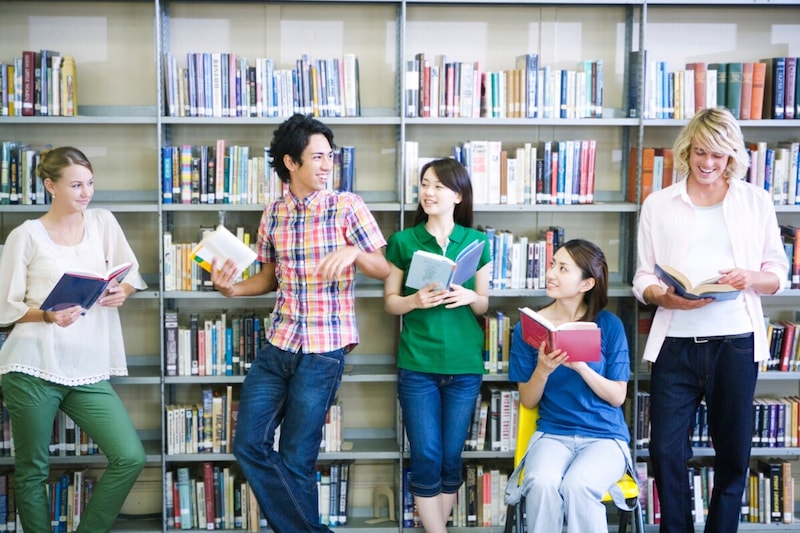 여러 국적의 사람들이 책장 앞에서 웃으며 대화를 나누는 모습