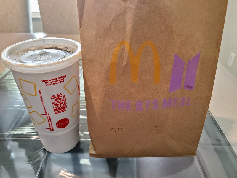 식탁-위에-라지콜라-맥도날드-BTS-MEAL이-담긴-봉투가-올려진-사진