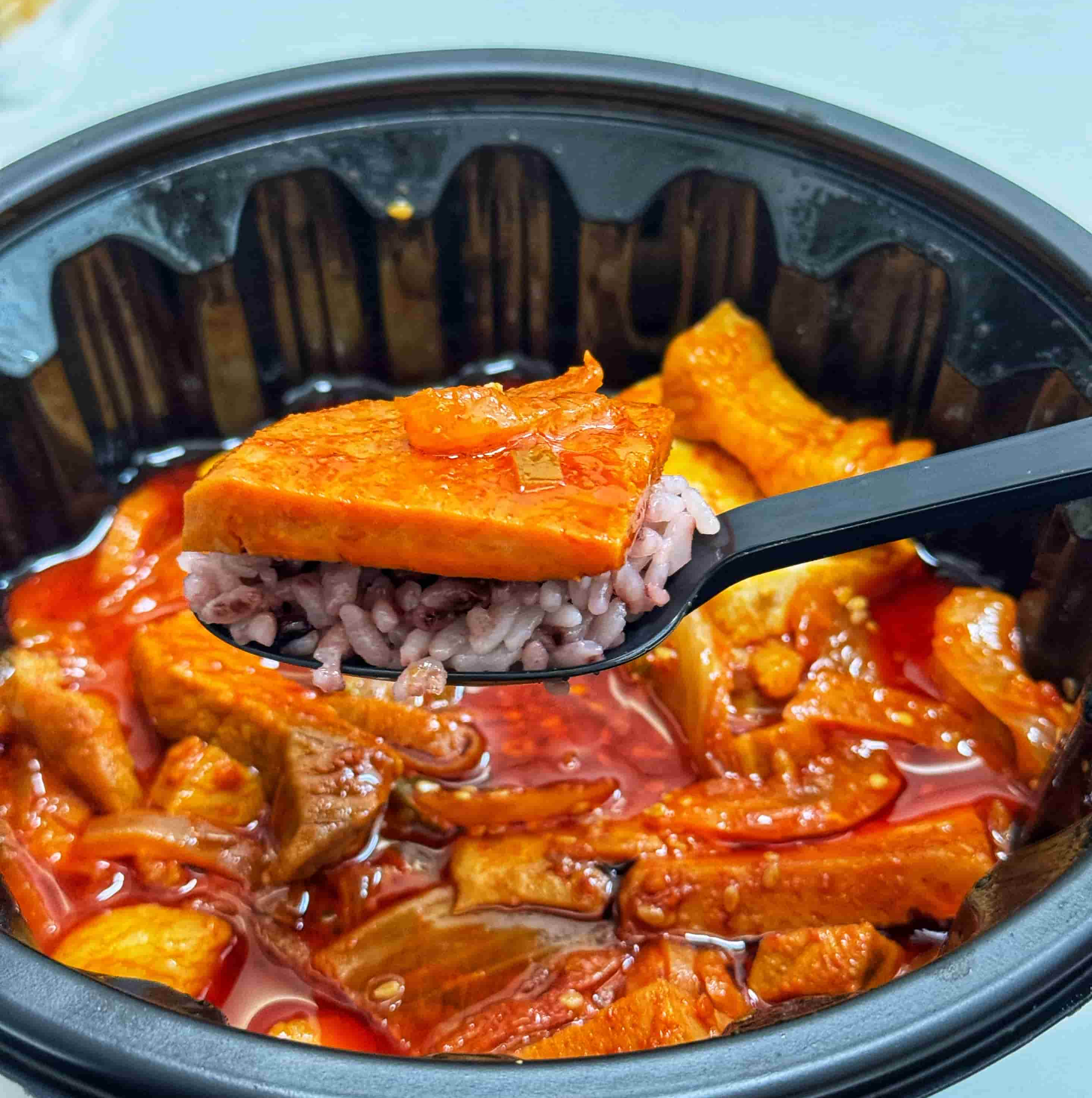 흑돼지 짜글이에 들어 있는 스팸과 밥을 먹는 사진