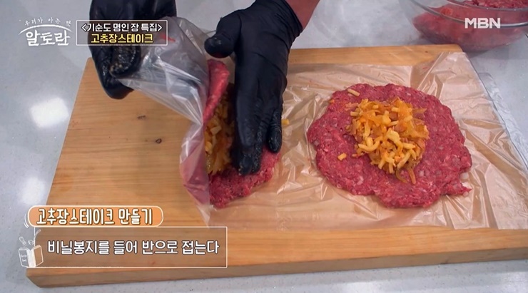 고기반죽에-양파볶음을-올려-비닐봉지를-접는다