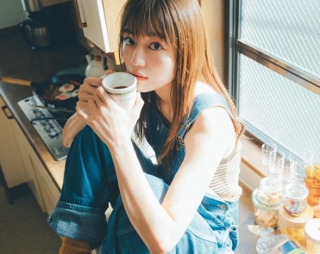 창가에 앉아 커피를 마시고 있는 여자의 모습