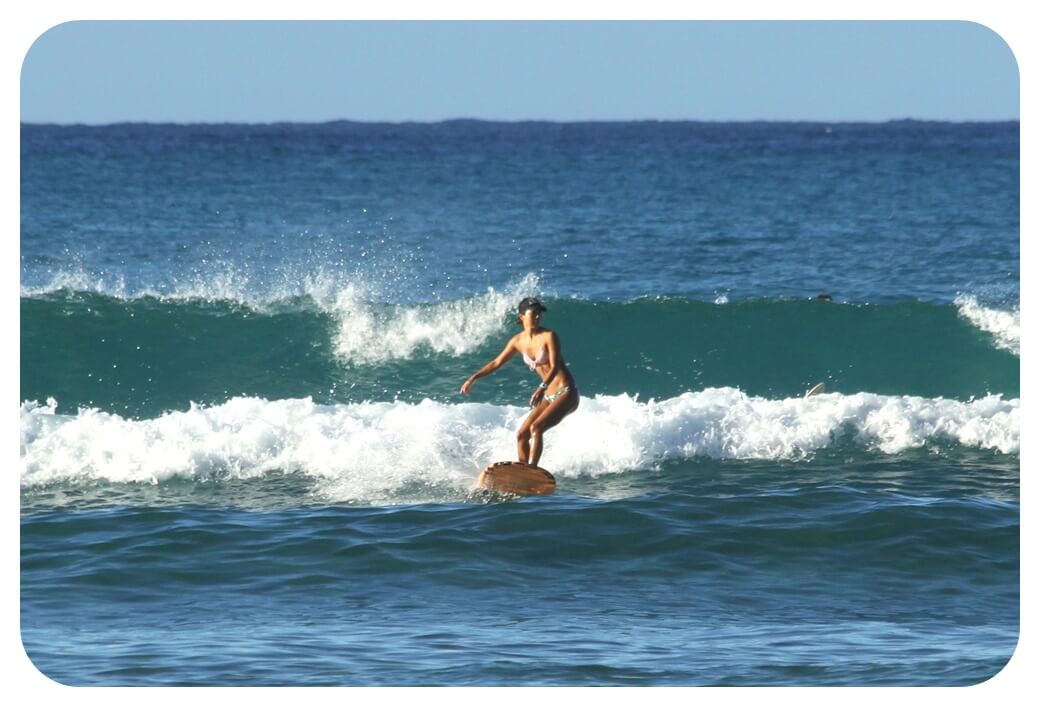 와이키키 해변에서 서핑을 즐기는 여성의 모습을 찍은 사진
