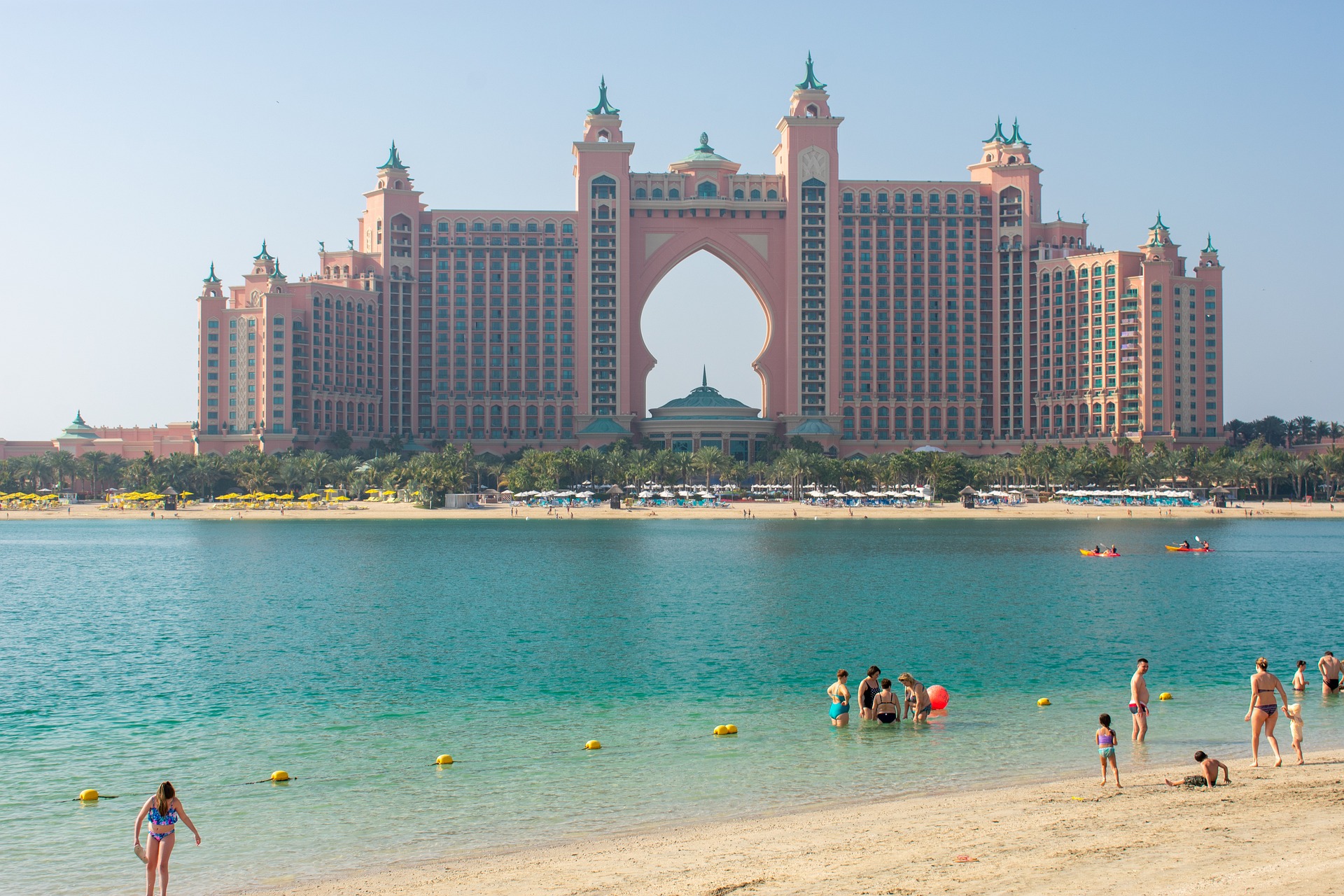 두바이 아틀란티스 더 팜이 멀리서 보이고&#44; 두바이 해변에서 노는 사람들도 함께 보이는 사진