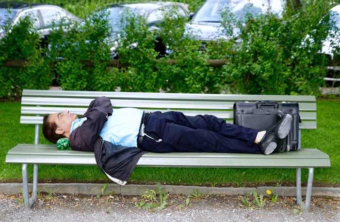 중년의 한 남성이 벤치에 누워 자고 있는 모습