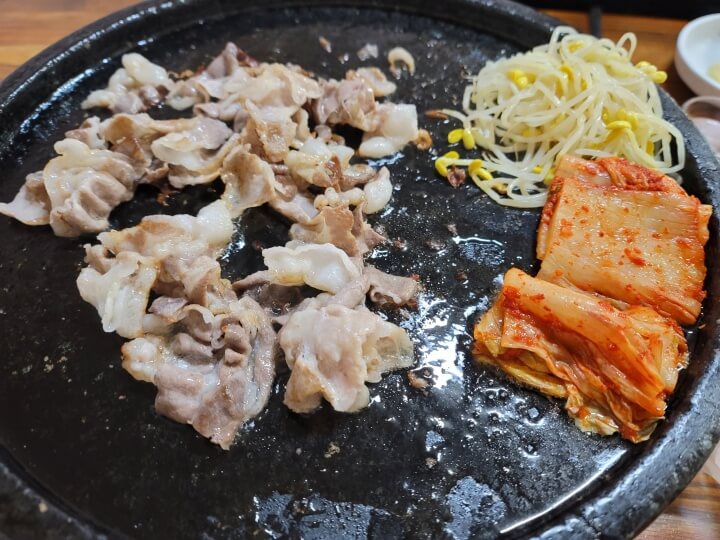 삼겹살 기름에 같이 구워지는 김치와 콩나물 사진