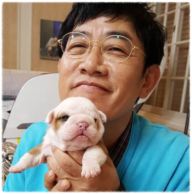 이경규가 조그만 강아지를 안고서 미소를 짓고 있는 모습. 얼굴 사진, 인티제 연예인이다.