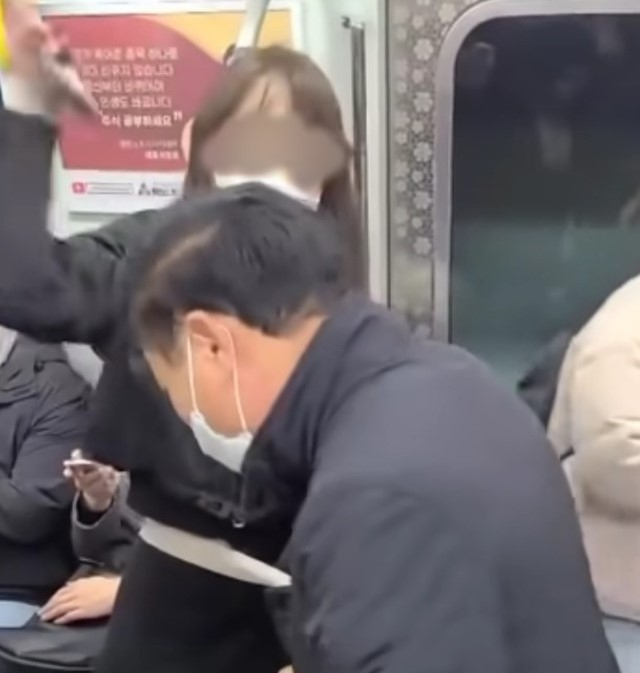 9호선 지하철역 20대 여성이 남성의 머리를 가격하고 있다.
