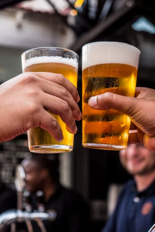 맥주 두잔과 그것을 즐겁게 바라보는 남성의 모습