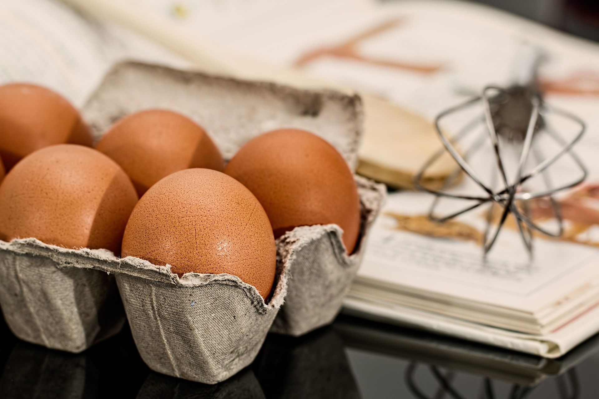 달걀을 달걀 보관함에 놓고&#44; 그 옆에 책과 주방도구를 놓고 찍은 사진 - 소양인(少陽人)에게 비교적 괜찮은 음식
