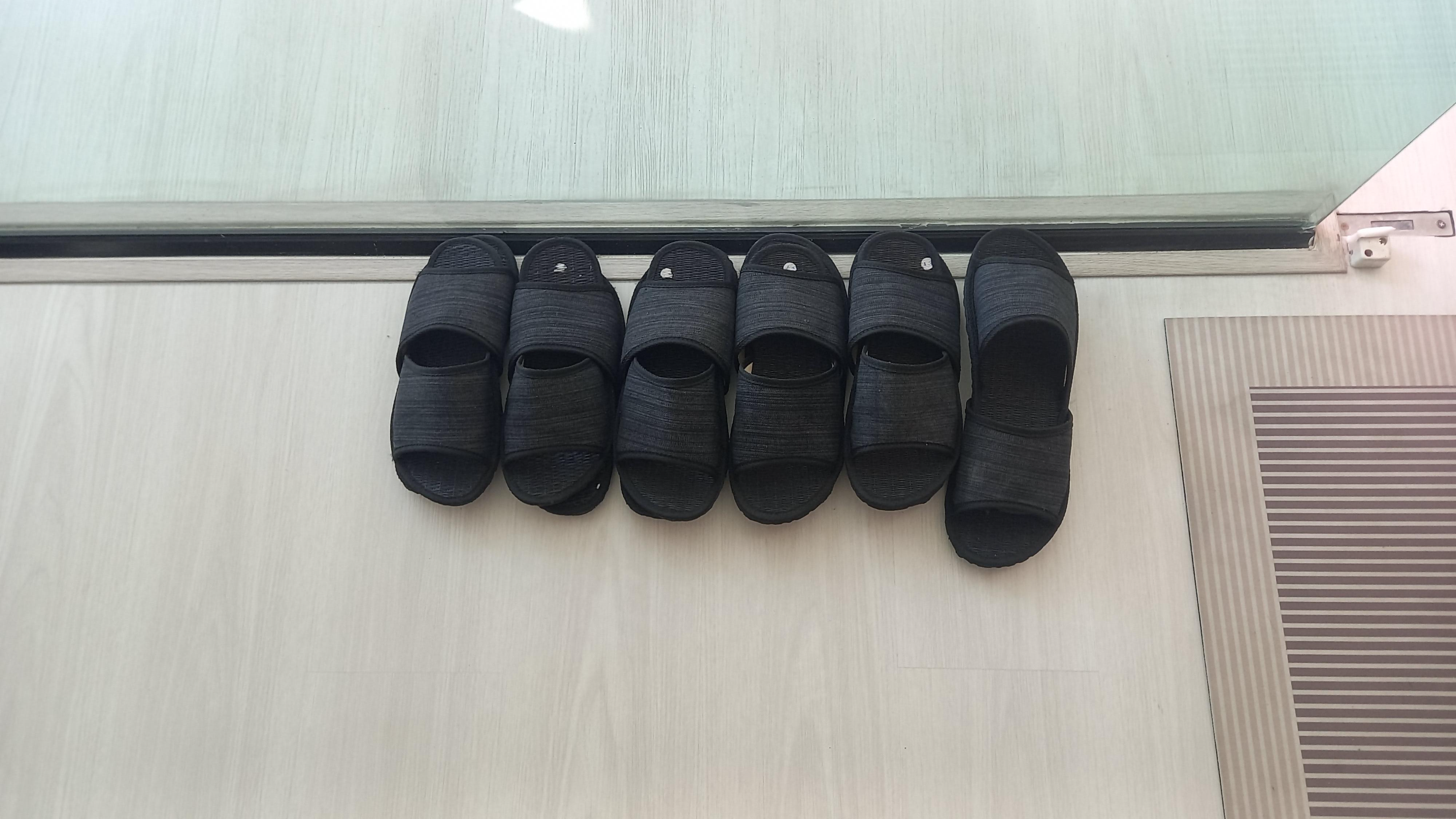 마사지샵 문 옆에 가지런히 포개서 놓여 있는 슬리퍼
