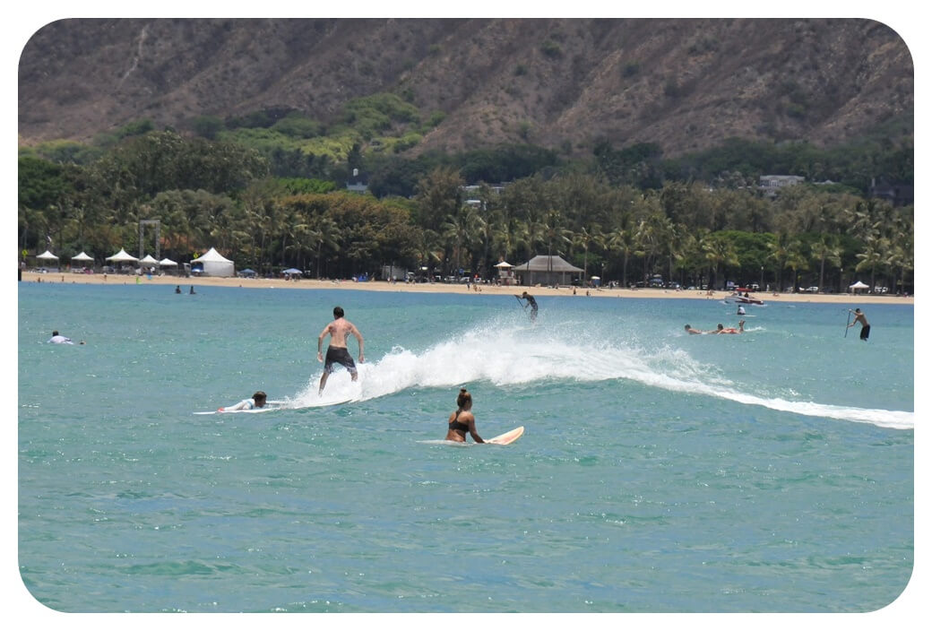 퀸즈 비치 해안가에서 서핑하는 사람들을 찍은 사진