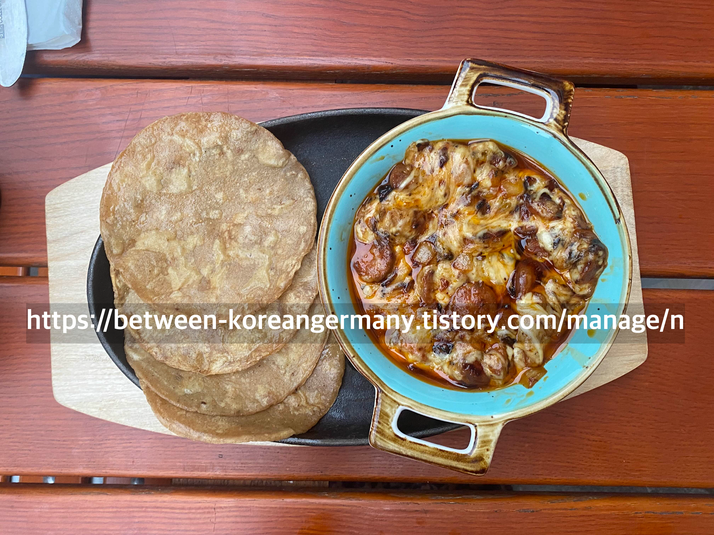 작은 그릇에 담긴 소세지와 치즈가 담긴 파란색 그릇과 타코