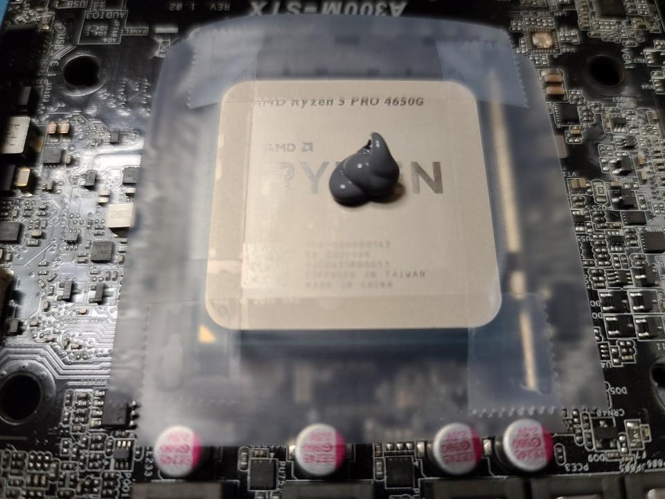사면이 스카치테이프로 둘러싼 RYZEN CPU 위에 써멀구리스 도포