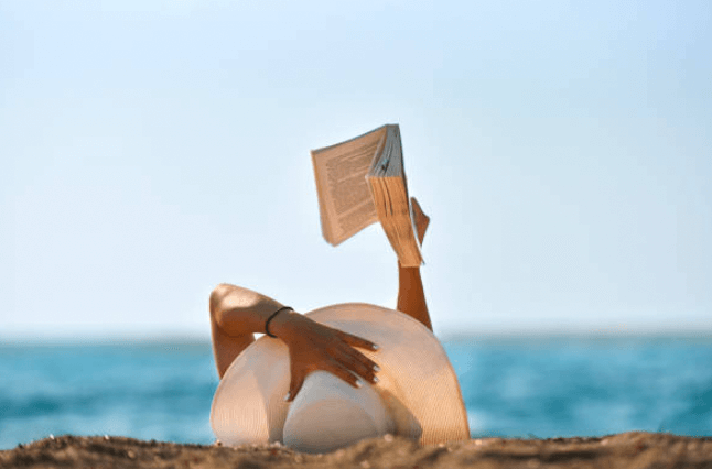 해변에 누워 책 읽는 여자