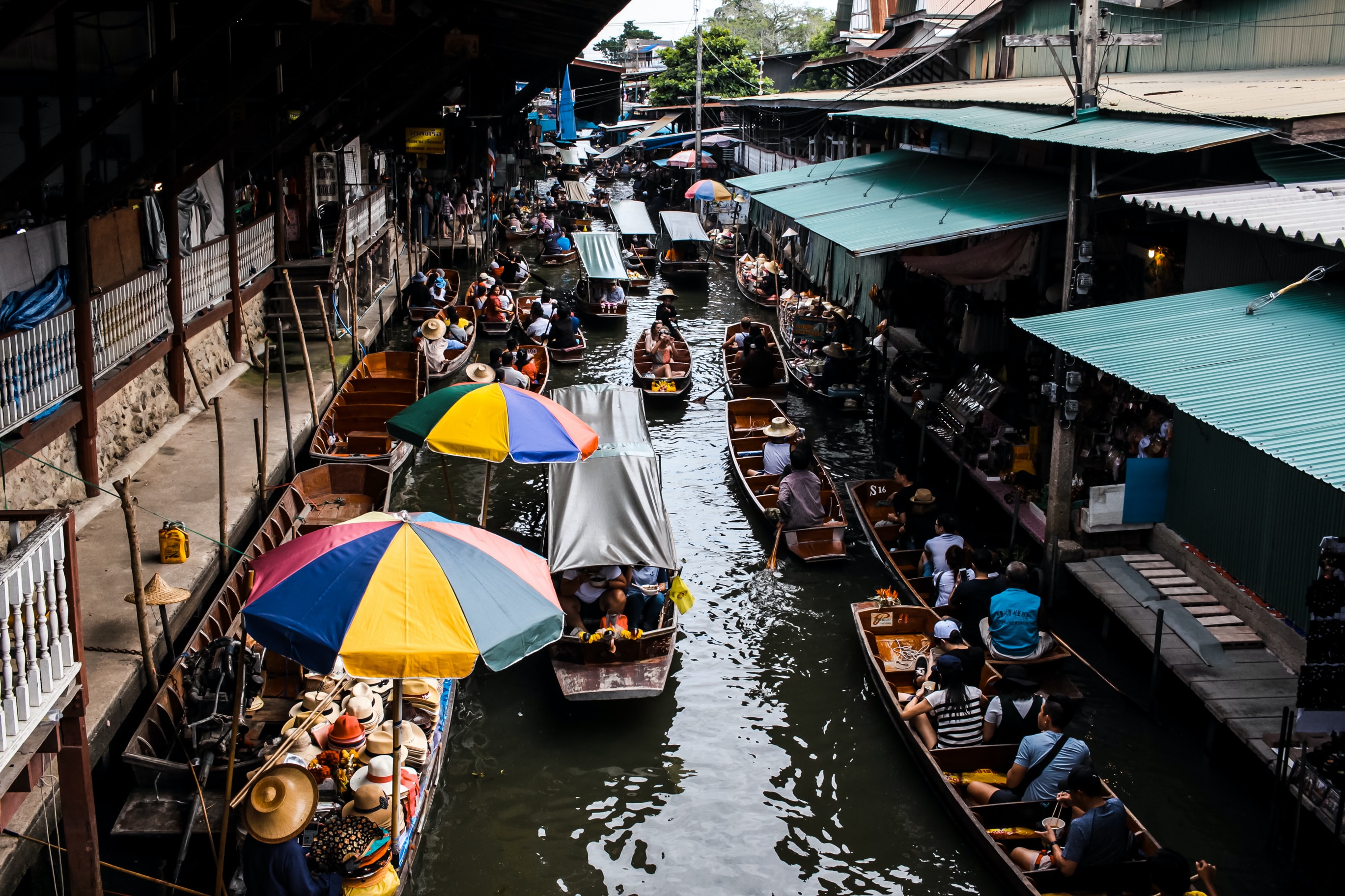 태국 방콕의 강에서 사람들이 배를 타고 지나다니는 모습