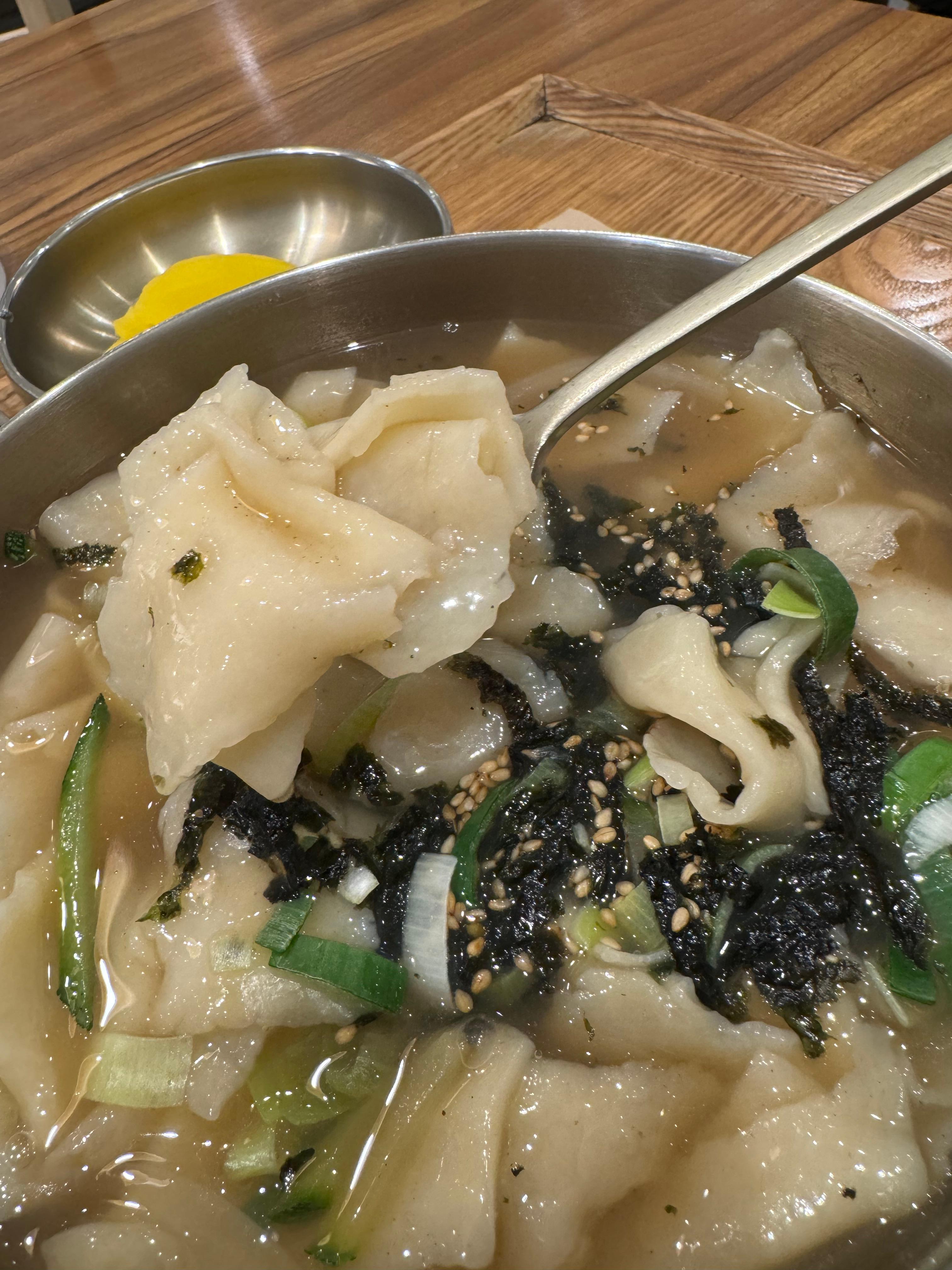 수제비 클로즈업 사진. 맑은 국물 안에 수제비들이 먹음직스러워 보인다.