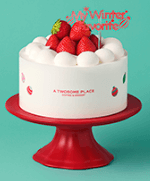 흰 생크림 케이크 위 동그란 생크림 가운데 딸기