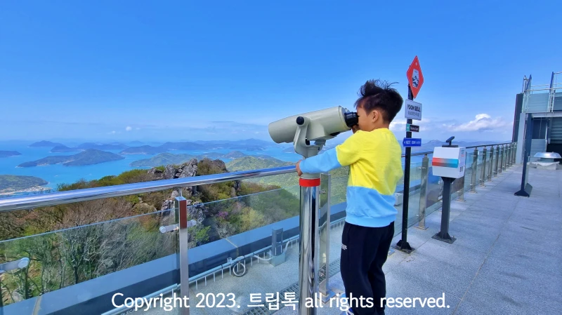 루프탑에서 한려해상 바다를 망원경으로 보고 있는 남자아이