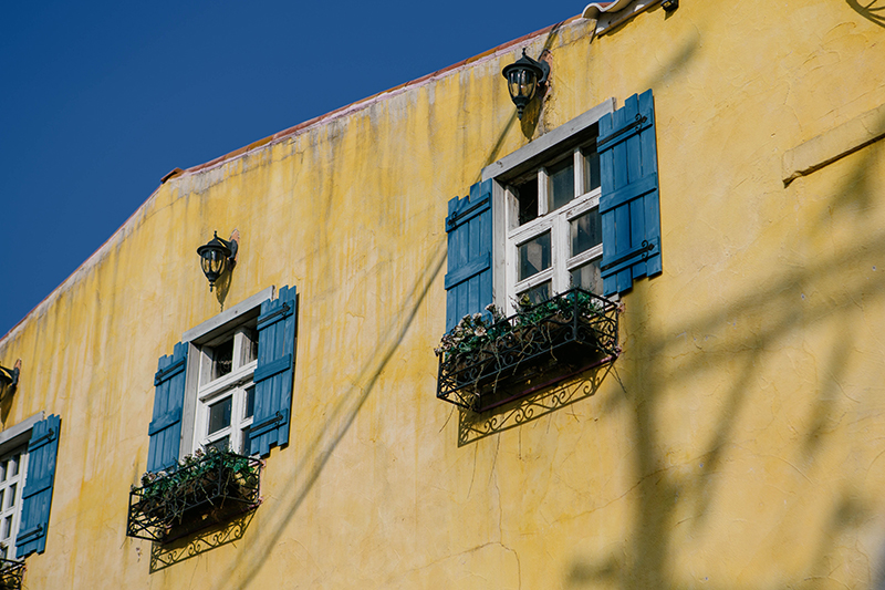 파주 프로방스 마을. 노란벽에 흰 창문. 그리고 파란색 창문 닫이가 이국적인 모습. 전봇대 그림자가 노란벽에 드리워져 있다.