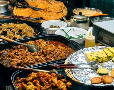 보통 한국 잔치 음식으로 많이 나오는 잡채, 제육볶음, 김말이, 김치전, 등 푸짐한 음식들이 보이는 사진