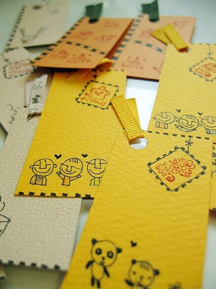 작은 직사각형 모양으로 자른 베이지색, 연주황색, 노란색 종이에 귀여운 그림들이 그려져 있는 모습