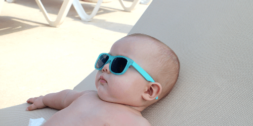 선글라스를 끼고 야외 선배드에 누워있는 아기 사진