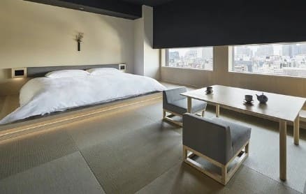 좌식 테이블과 의자 그리고 일본식의 낮은 침대가 있는 객실