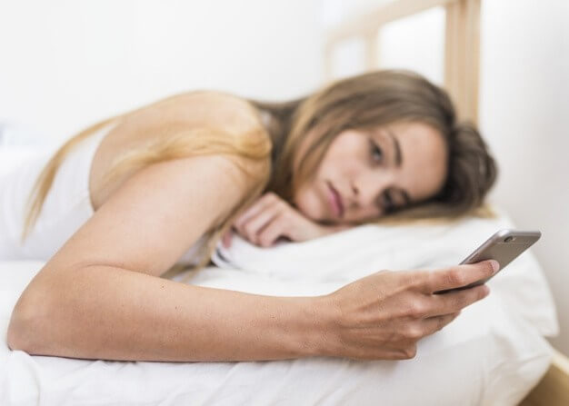 침대에서-스마트폰을-보는여성