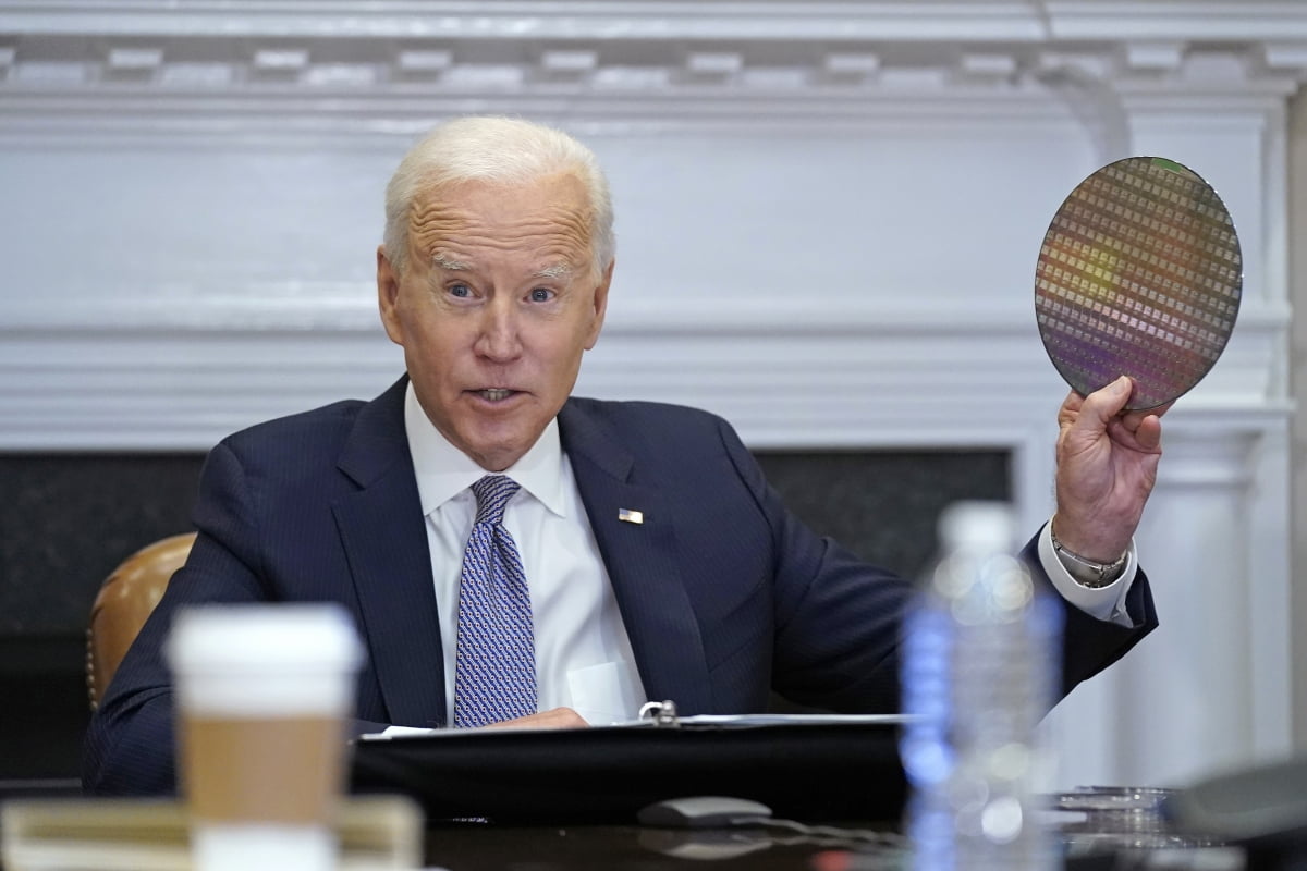 조 바이든 미국 대통령이 2021년 백악관에서 열린 반도체 CEO들과의 화상 회의에서 반도체 웨이퍼를 집어들었다.