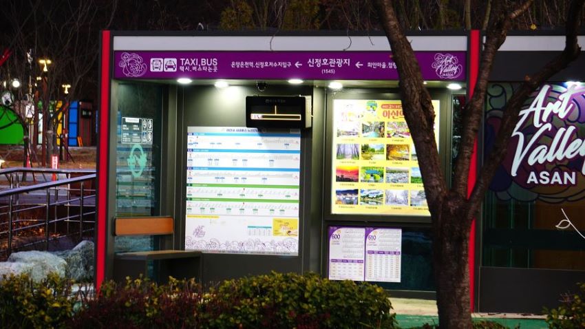 야경, 불 들어온 버스정류장, 벽에 붙여놓은 노선 안내도, 시간표, 우측에 추위 피하는 공간, 유리창에 쓰인 영문 아트밸리,