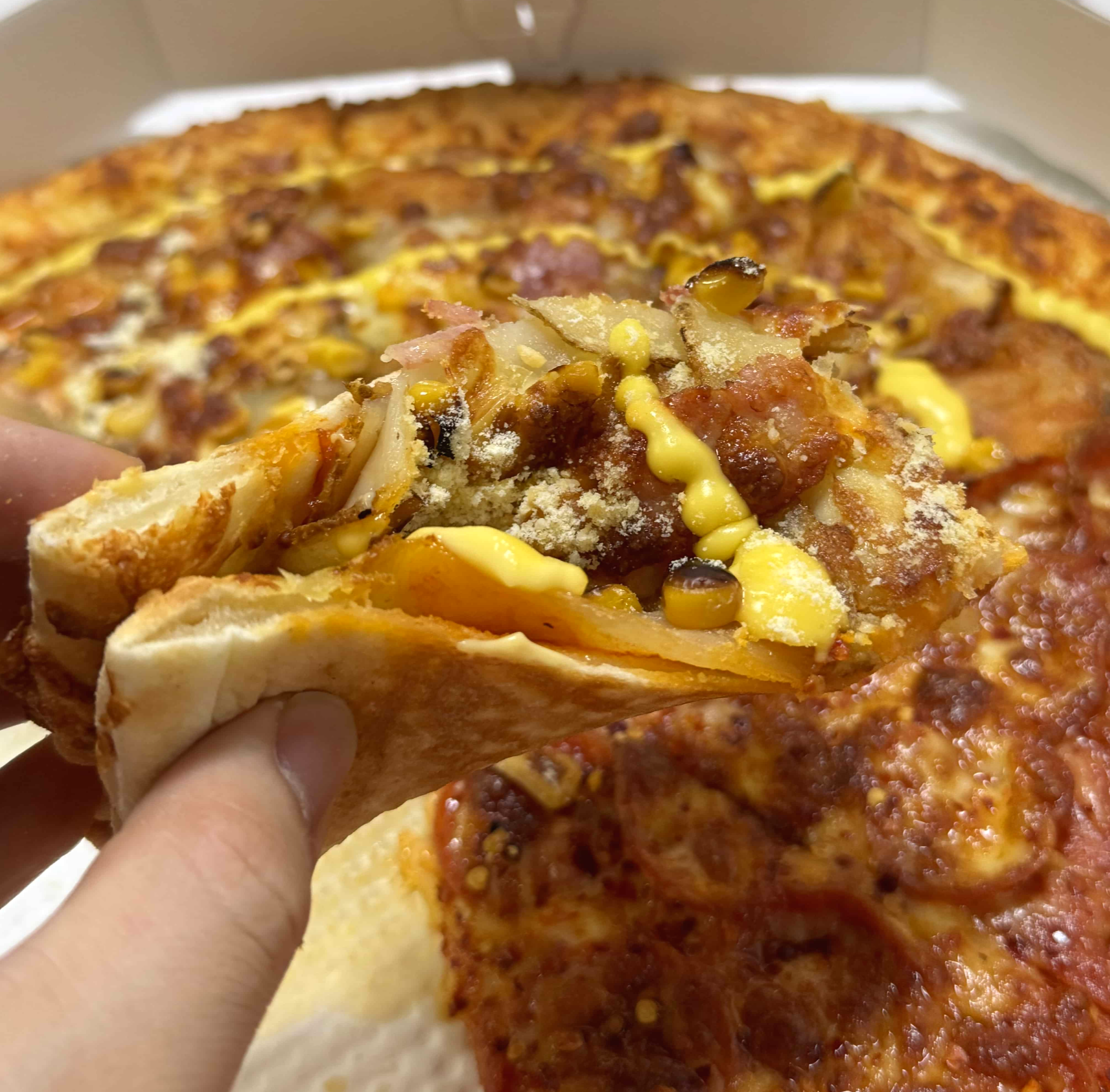 허리케인 포테이토 피자를 손으로 집은 모습을 찍은 사진이다.