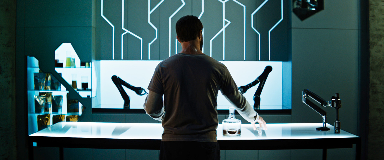 밝은 테이블 스크린을 이용해 로봇 팔을 움직이는 그레이의 뒷모습이다.