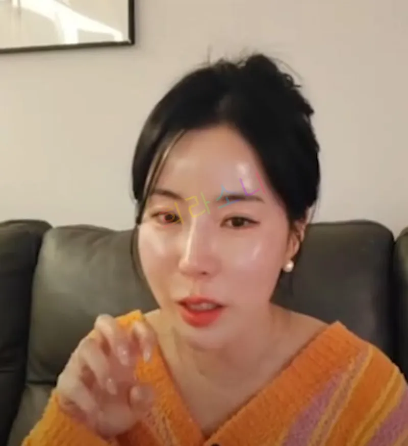 10기 영숙이 거실 소파에 앉아 카메라를 바라보며 말하는 듯한 표정을 짓고 있다. 그녀는 오렌지와 핑크 스트라이프 패턴의 포근한 가운을 입고 있으며&amp;#44; 진주 귀걸이를 착용하고 있다. 그녀의 손가락은 고양이 발톱을 흉내 내듯 살짝 구부려져 있다. 자막에는 &amp;quot;희라소니&amp;quot;라는 텍스트가 보인다.