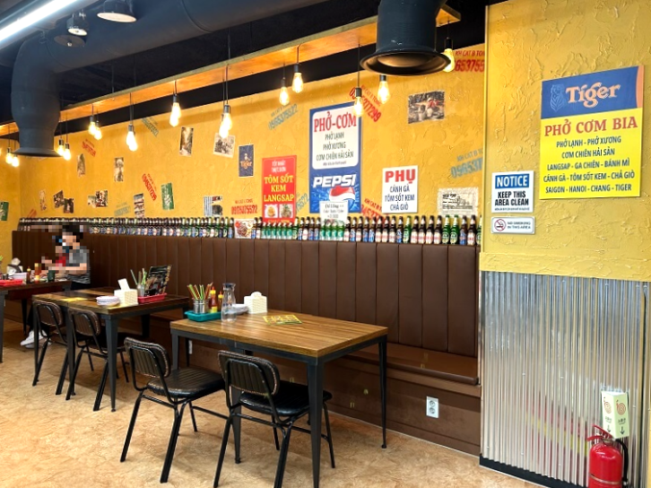 갈색-의자와-테이블-여러개와-사람들이-있는-음식점-내부를-찍은-사진