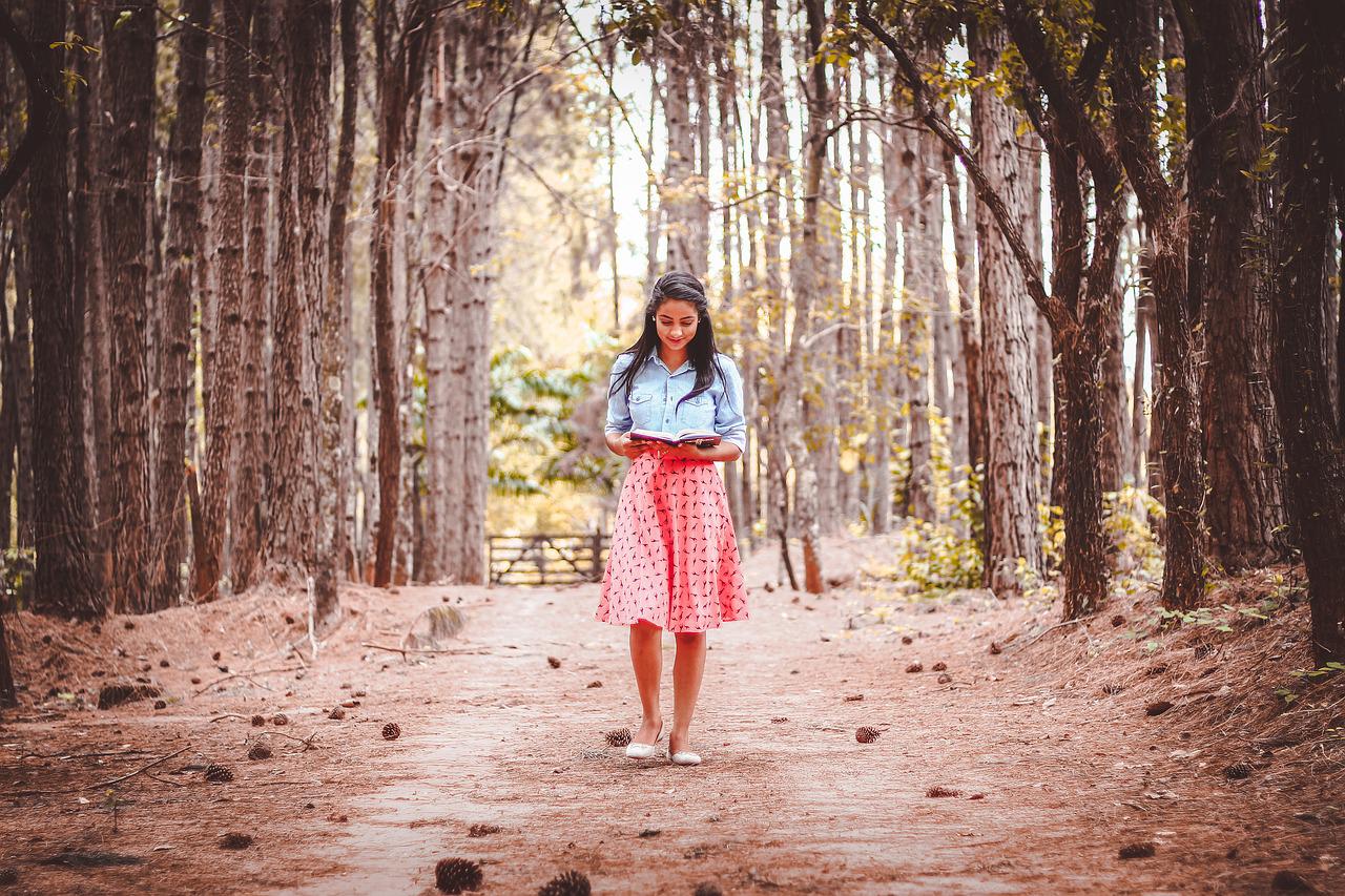 숲길에서 혼자 사색을 하며 책을 읽는 여자