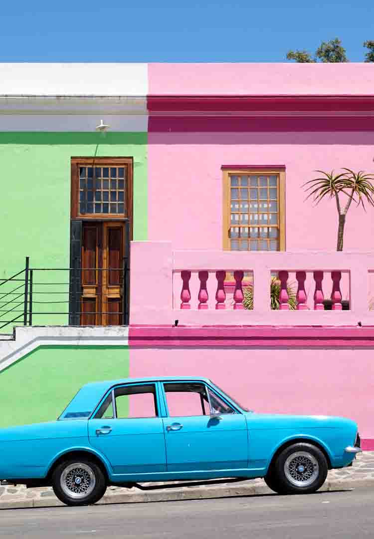 연두색벽-분홍색벽으로-이루어진-집앞에-주차되어진-하늘색차