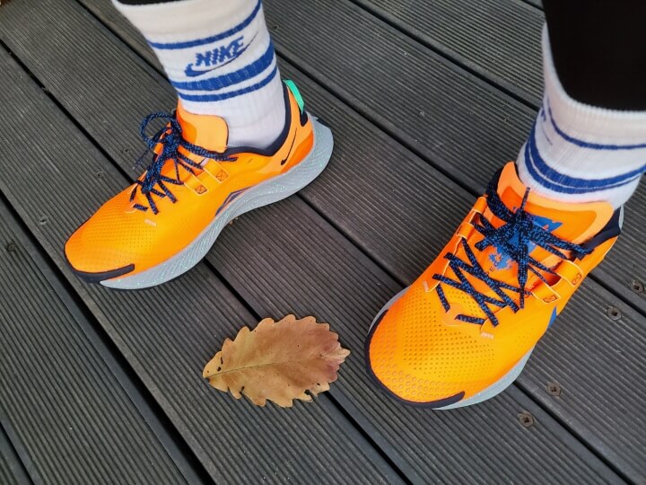 나이키 페가수스 트레일3 신발을 신고 나무 바닥에 서있는 사진