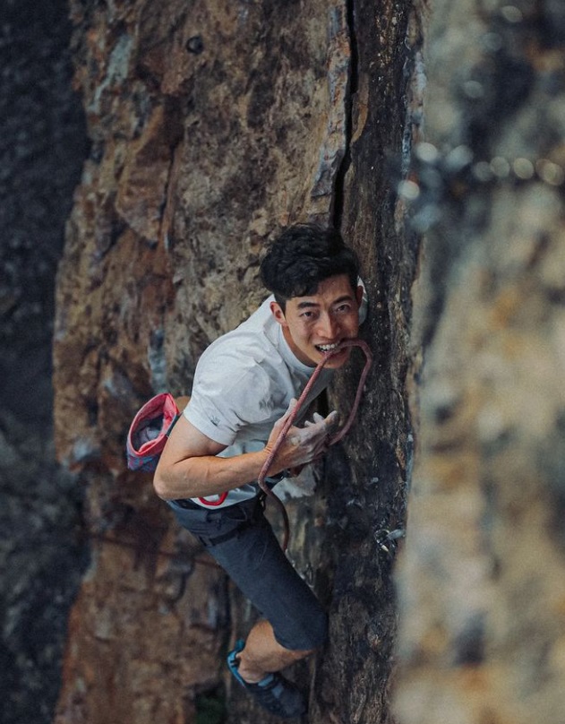김민철이 밧줄을 입에 문재로 암벽 등반을 하고 위를 보고 있는 사진