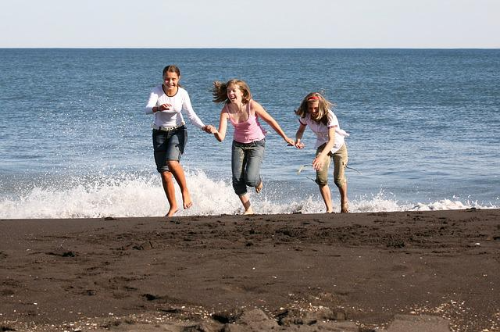 파도치는 바닷가에서 달려오고 있는 소녀 세명 친구