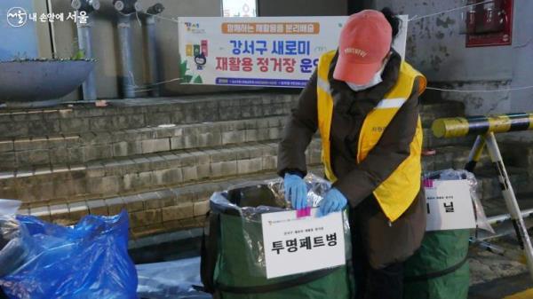 재활용 분리수거함에 자원관리사가 항목별로 이름표를 부착하고 있다. ⓒ박분