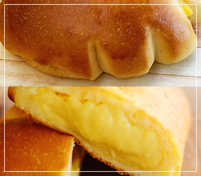 슈크림 빵의 사진입니다. 먹음직스러운 빵을 반 짤라 놓았는데 빵속에 노락색의 크림이 가득 들어있습니다.