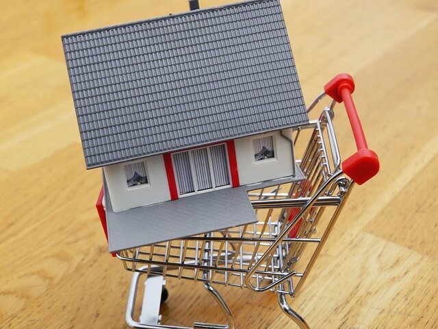 마트에 있는 카트 모형 위에 담긴 집 모양 모형