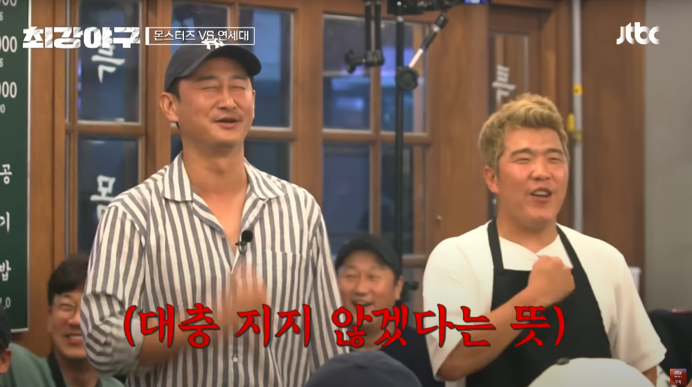 가슴에 손을 얹고 노래를 부르는 두 남자