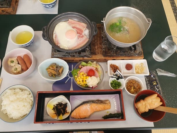 일본식 음식들이 테이블 위에 올려져 있다. 연어구이 낫또&#44; 일본식 된장국등이 보인다