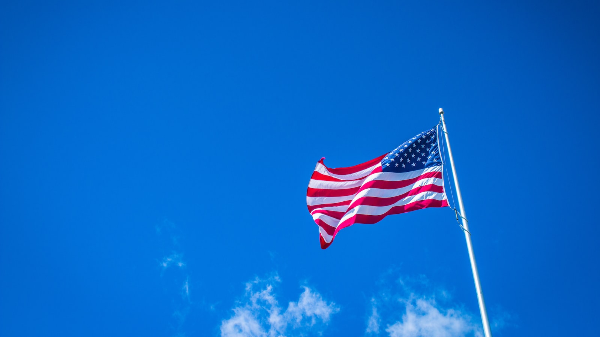 The American flag against a blue sky background.